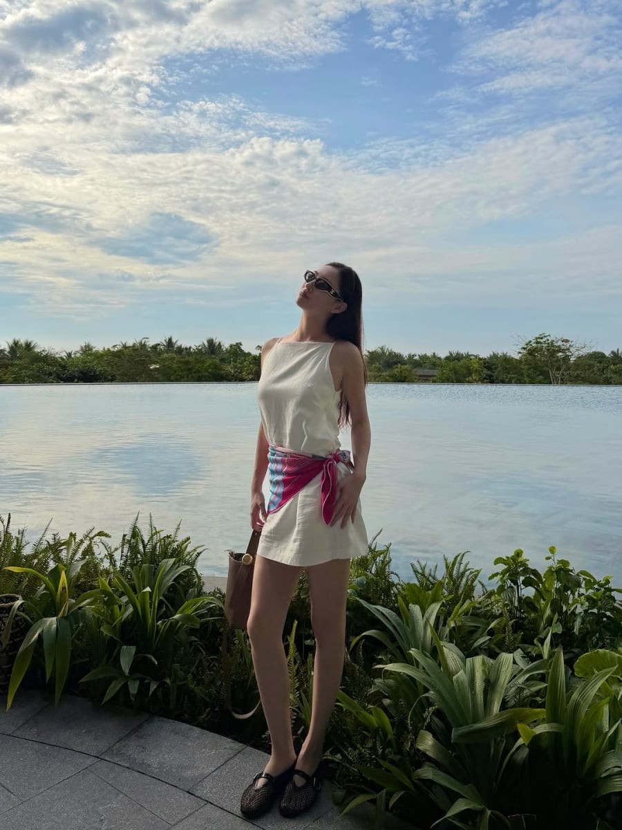 Chiếc váy trắng không tay với đường cắt may gọn gàng là minh chứng rõ nét cho phong cách tối giản mà cô theo đuổi.
