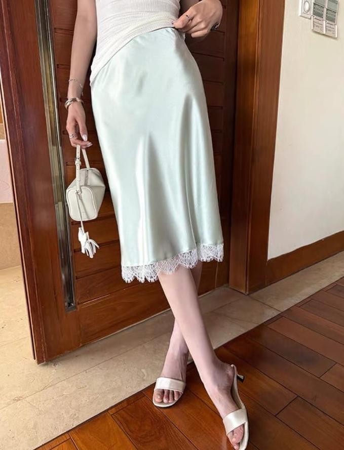 Sự tương phản giữa chất liệu lụa mềm mại và áo thun cơ bản tạo nên tổng thể hiện đại mà vẫn tinh tế.