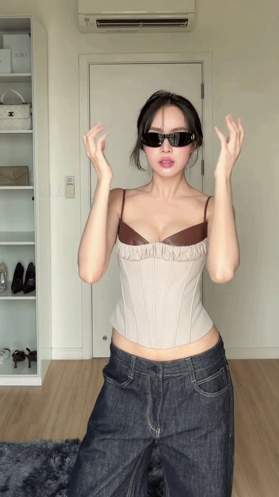  Một trong những set đồ gây chú ý gần đây là sự kết hợp giữa áo corset màu kem ôm sát cơ thể và quần jeans ống rộng màu tối.