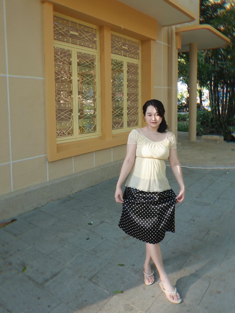 Một trong những bộ trang phục nổi bật gần đây là sự kết hợp giữa áo trễ vai màu vàng nhạt và chân váy midi họa tiết chấm bi. 