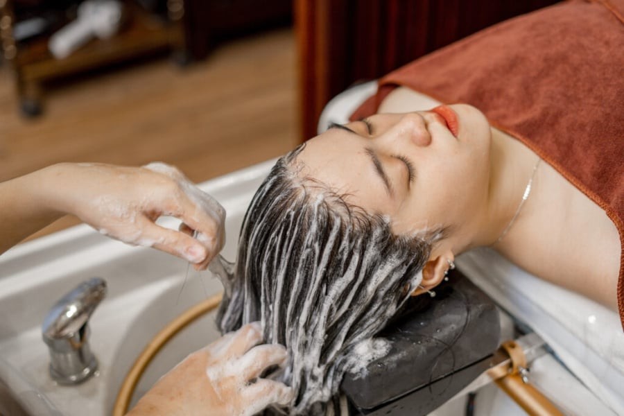 Bạn có thể chia dầu gội thành nhiều điểm như vùng chân tóc phía trước, đỉnh đầu, hai bên thái dương và sau gáy trước khi tạo bọt. 