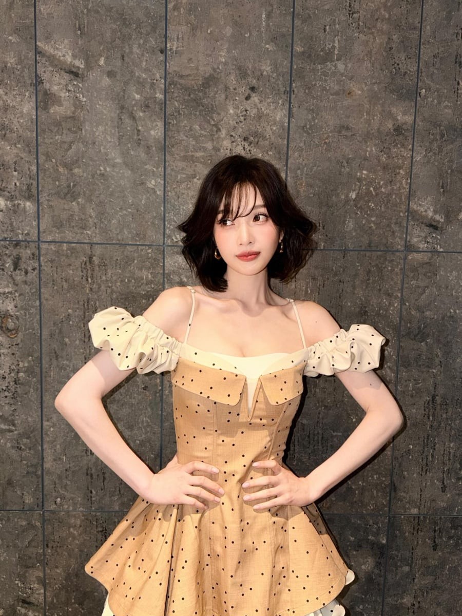 Một trong những outfit nổi bật là chiếc váy corset tông màu be kết hợp tay phồng trắng cùng họa tiết chấm bi nhỏ.