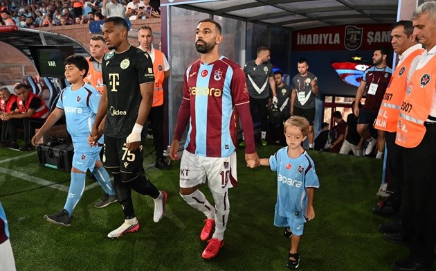 Salah bước ra ngoài cùng cậu bé Isaac, một người hâm mộ cuồng nhiệt của đội. (Ảnh: Getty Images)