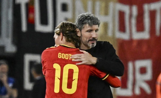Mark van Bommel ôm lấy trò cưng Mika Godts sau trận đấu. Ảnh: EPA.