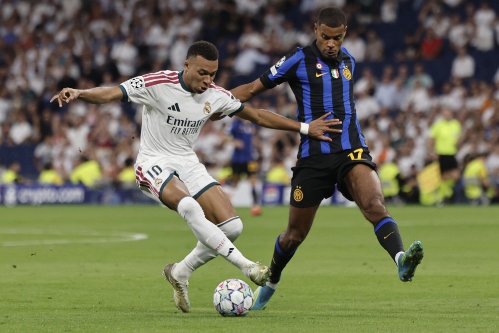 Andy Diouf (áo xanh) ở tình huống tranh bóng với Mbappe. Ảnh: EPA.