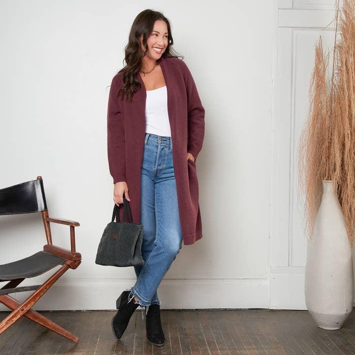 Cardigan tím mận phối cùng quần jeans xanh và áo trắng tạo nên diện mạo trẻ trung, nữ tính, giúp gam màu trầm trở nên hiện đại hơn.