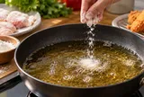Vì sao người nội trợ lâu năm thường rắc một nhúm bột vào chảo dầu trước khi chiên?