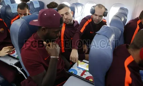 Iniesta và Umtiti tranh thủ chơi game lúc Alba ngủ quên