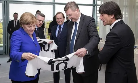 Bà Merkel lại mơ vào phòng thay đồ chụp ảnh cùng tuyển Đức