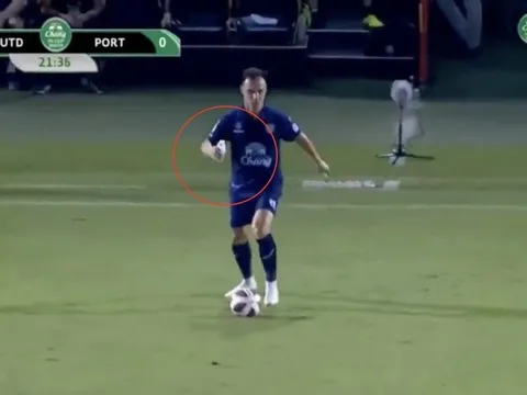 Hậu vệ Malaysia đá bóng với chai nước trên tay