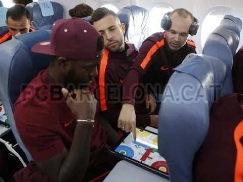 Iniesta và Umtiti tranh thủ chơi game lúc Alba ngủ quên